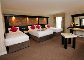 Habitación de hotel con dos camas, una mesita y un espejo.