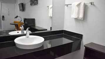 A modern bathroom with a black countertop, white sink, and a mirror.