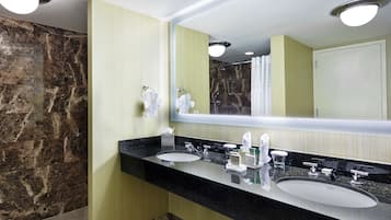 Un baño moderno con dos lavamanos, un espejo grande y zona de ducha.