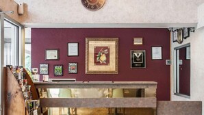 A reception area with a clock, framed certificates, and a wooden bookshelf.