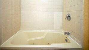 A bathroom with a bathtub, tiled walls, and a showerhead.