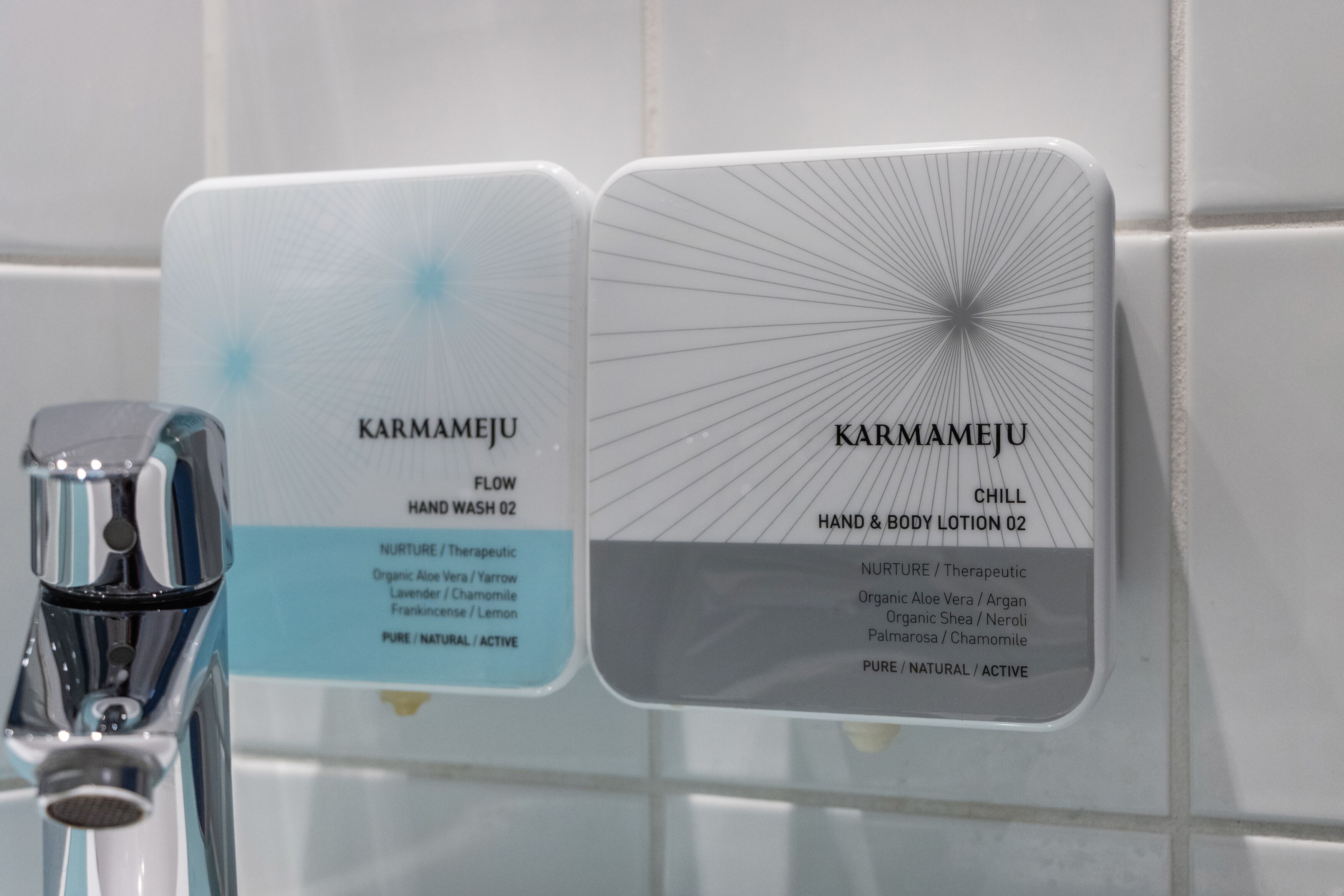 Dos dispensadores de jabón líquido para manos y loción corporal con la etiqueta 'KARMAMEJU', opciones 'FLOW' y 'CHILL'.