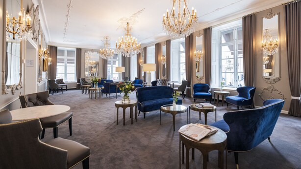 A spacious lounge area with multiple seating options, including sofas and armchairs, arranged around a central coffee table. - Phoenix Copenhagen (Copenhagen)
