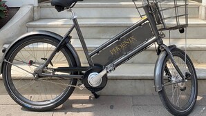 A bicycle parked outside a building with a grand entrance, a chandelier, and a staircase leading to an upper level. - Phoenix Copenhagen (Copenhagen)