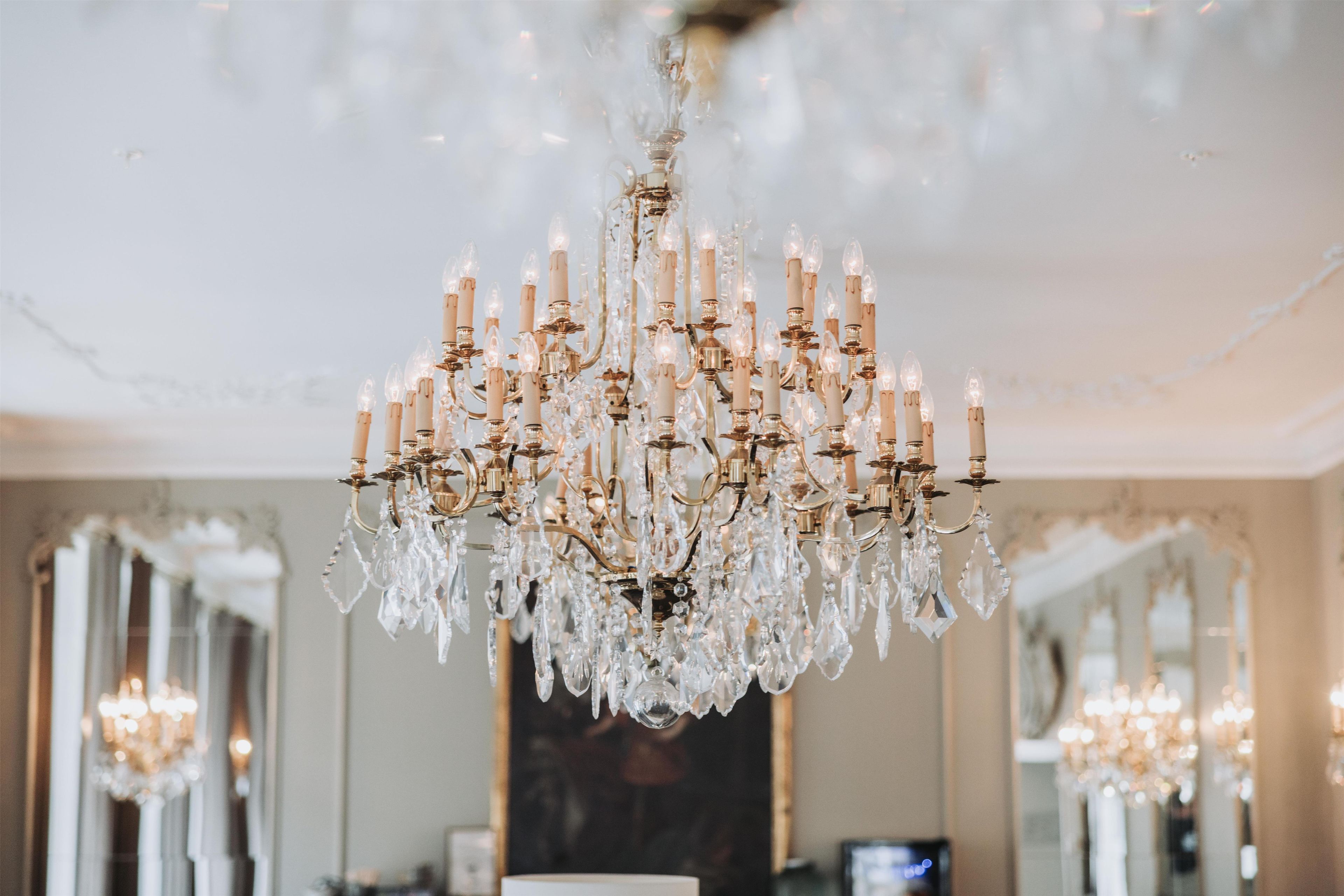A chandelier with multiple candle-like lights and crystal decorations.