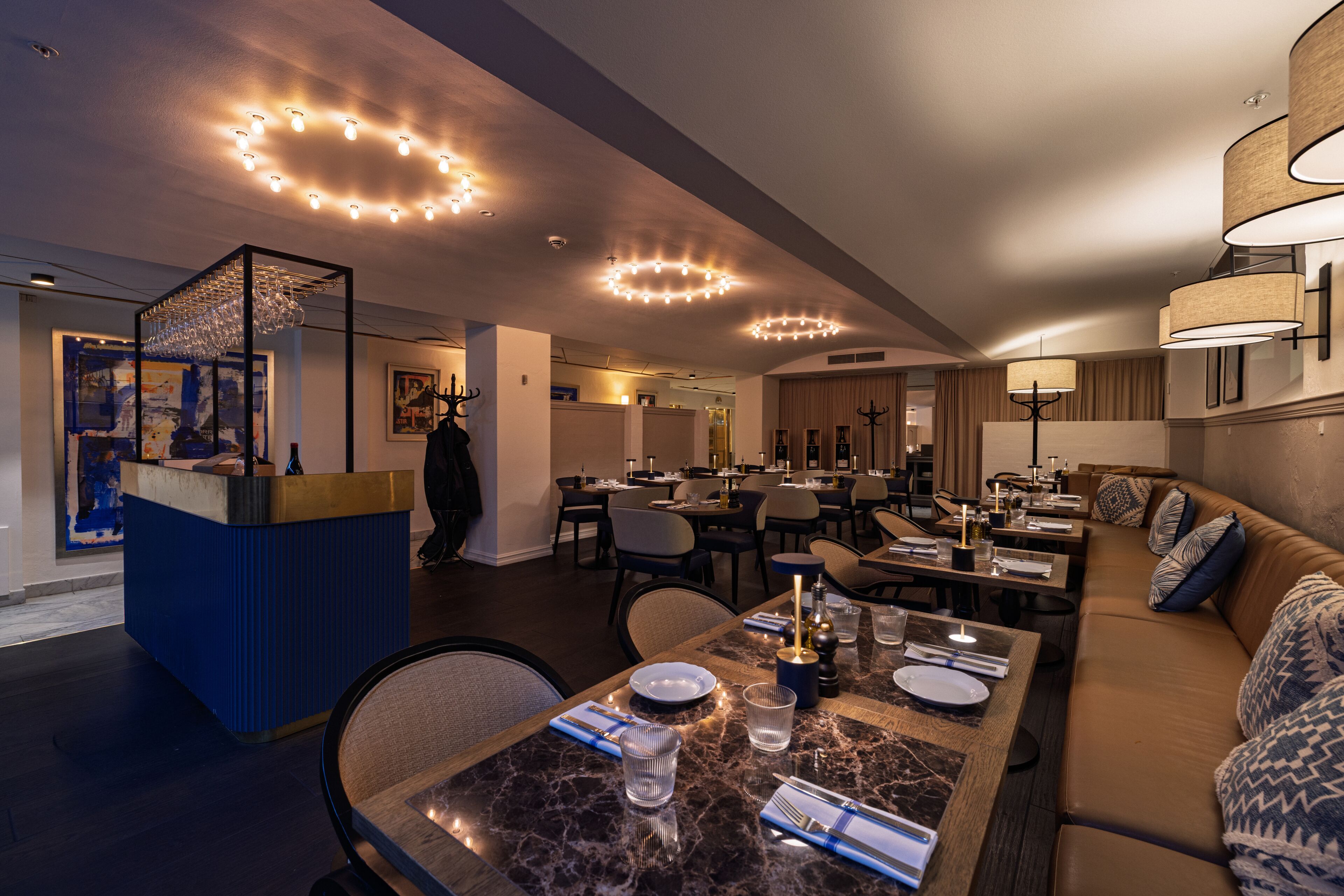 Un moderno vestíbulo de hotel con mostrador de recepción, zona de comedor y asientos.