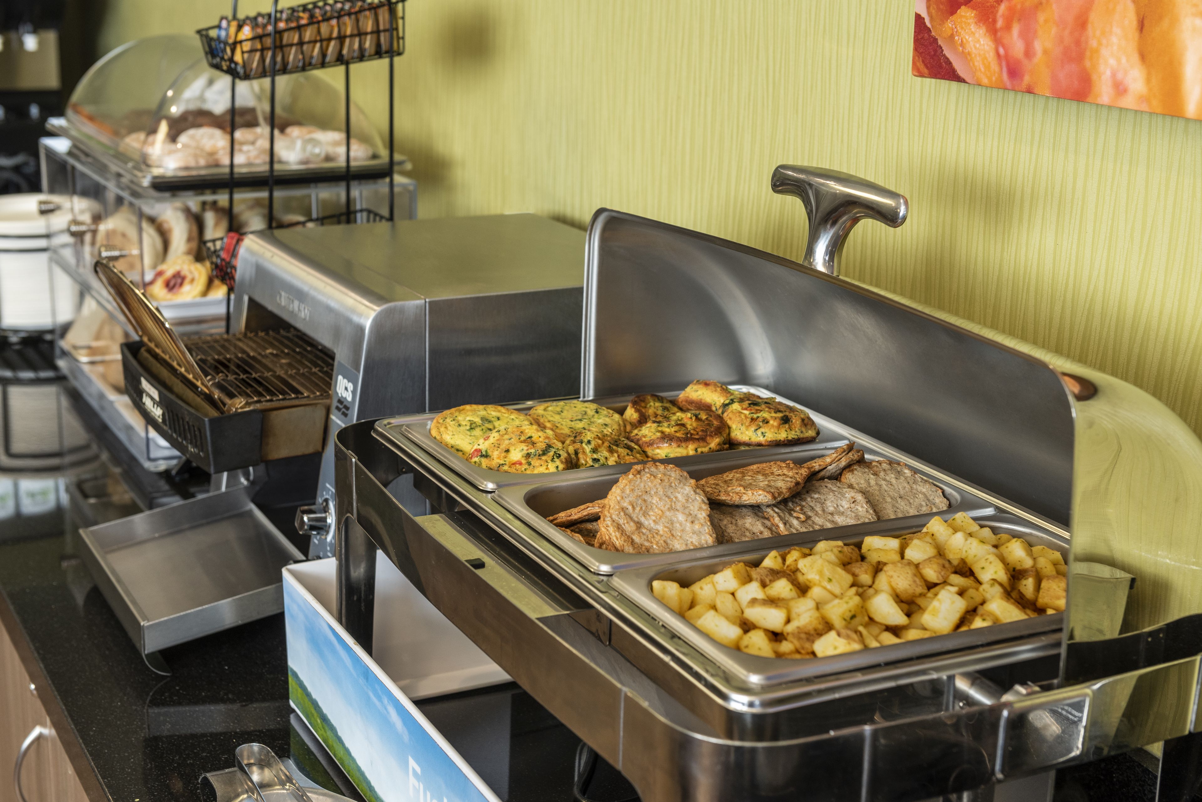 A buffet with various food items including potatoes, meats, and baked goods.