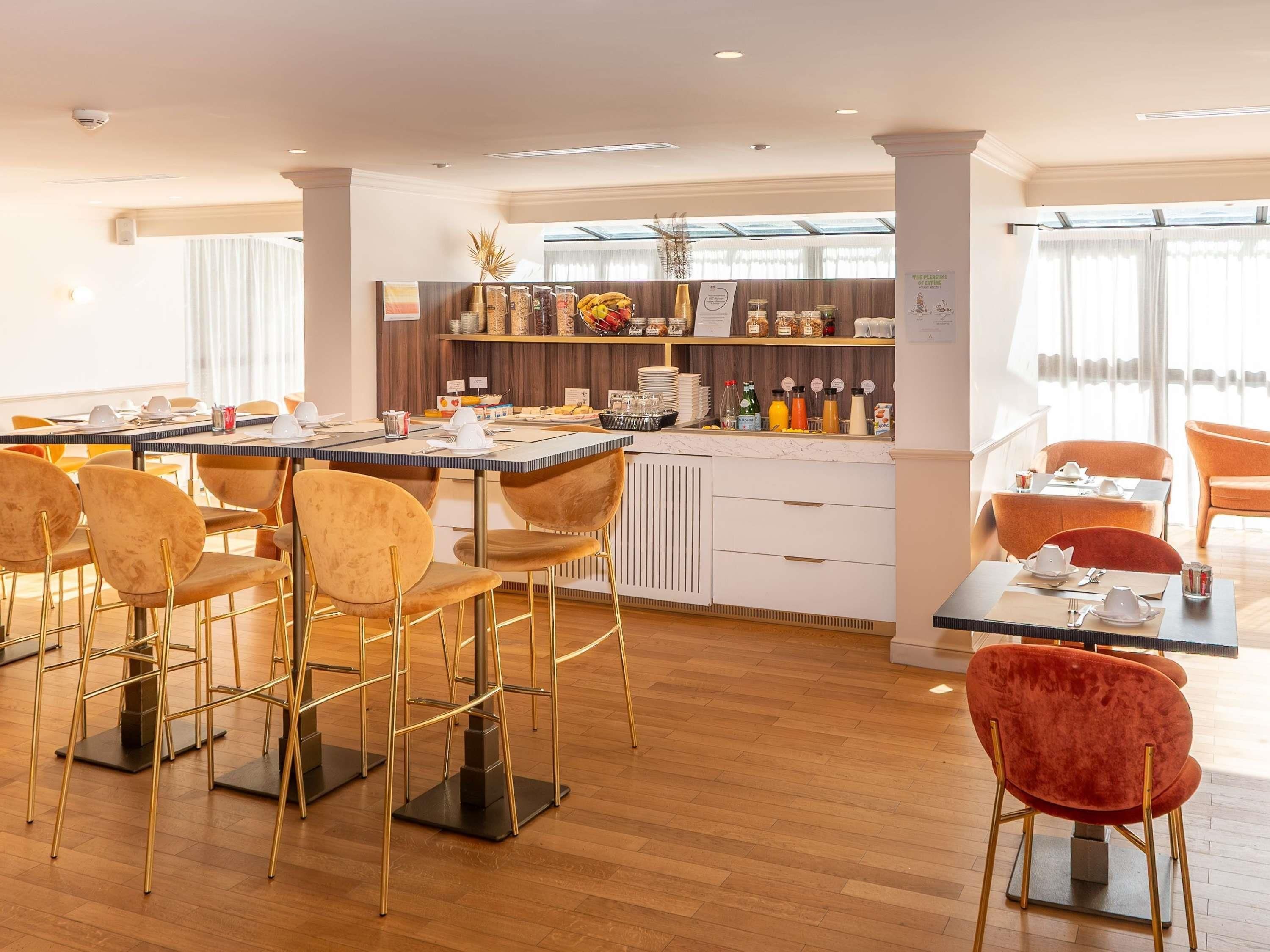 Un espace repas moderne doté d’un buffet, de sièges au bar et offrant une vue sur la ville.