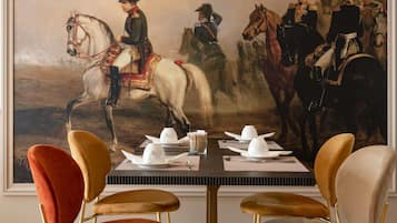 A dining table with a painting of horse-mounted soldiers, surrounded by modern chairs.