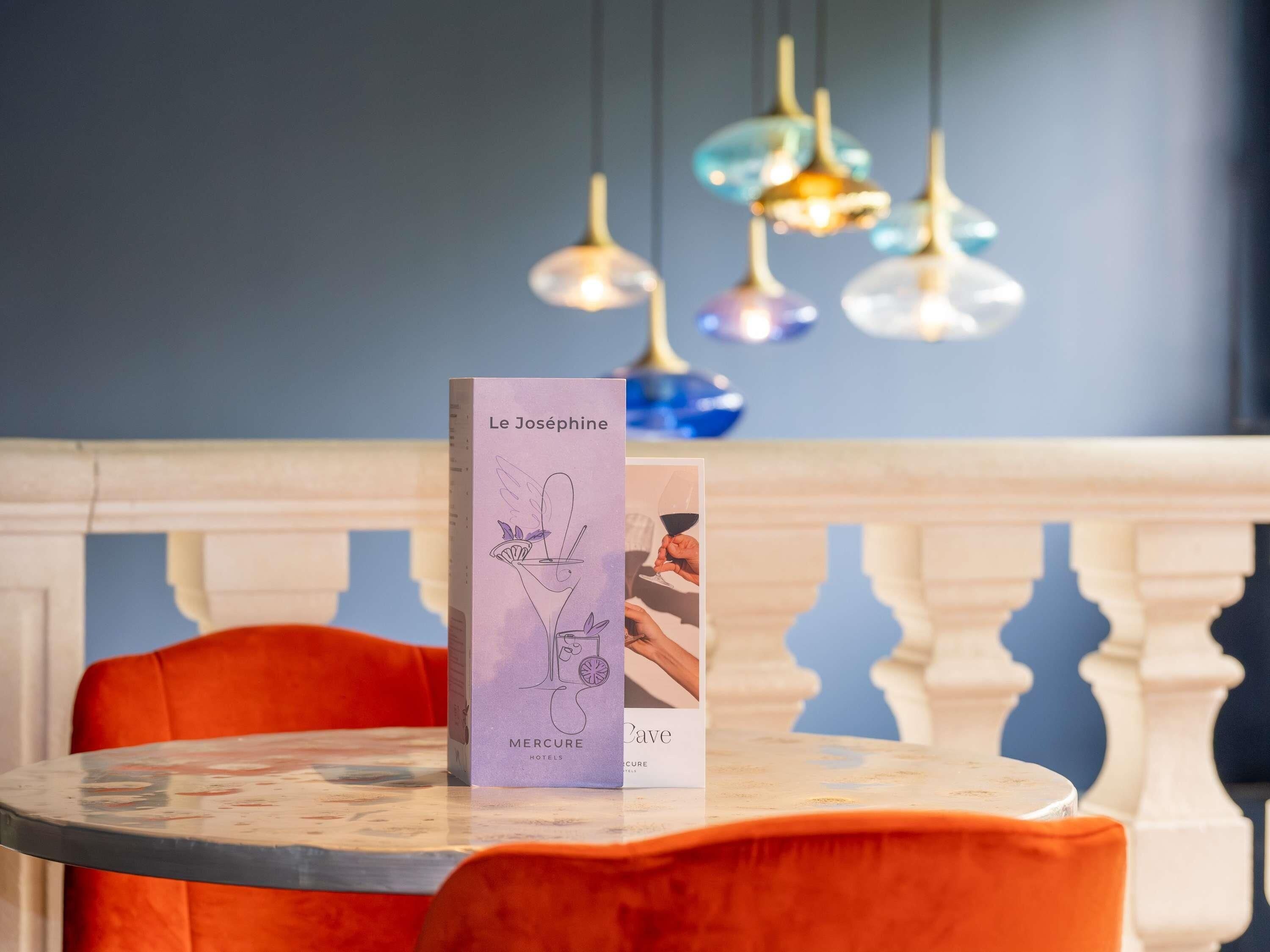 Une table dans un hôtel, sur laquelle se trouve un présentoir à menus affichant un menu intitulé « Le Joséphine ».