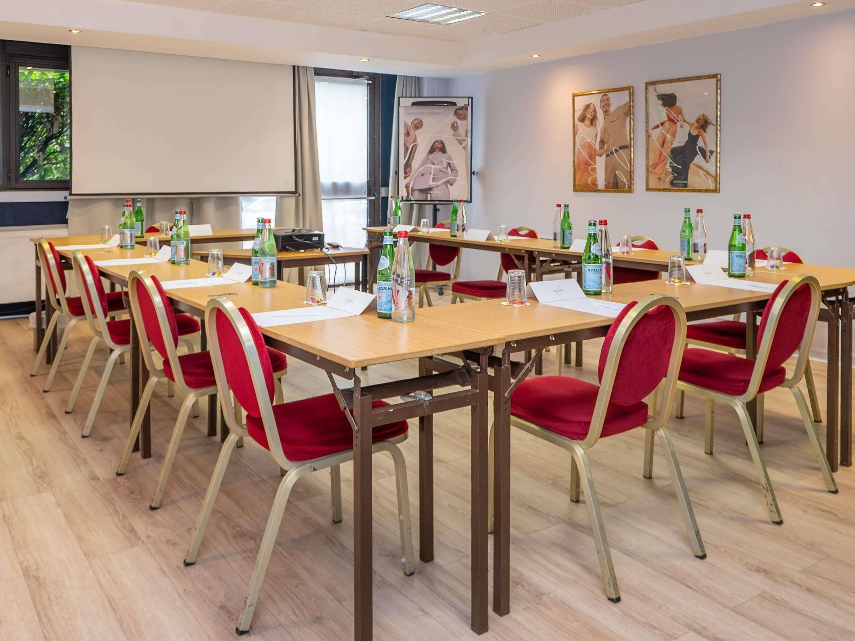 A conference room with tables, chairs, and water bottles.