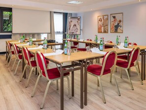 A conference room with tables, chairs, and water bottles. - Mercure Versailles Paris Ouest (Le Chesnay-Rocquencourt)