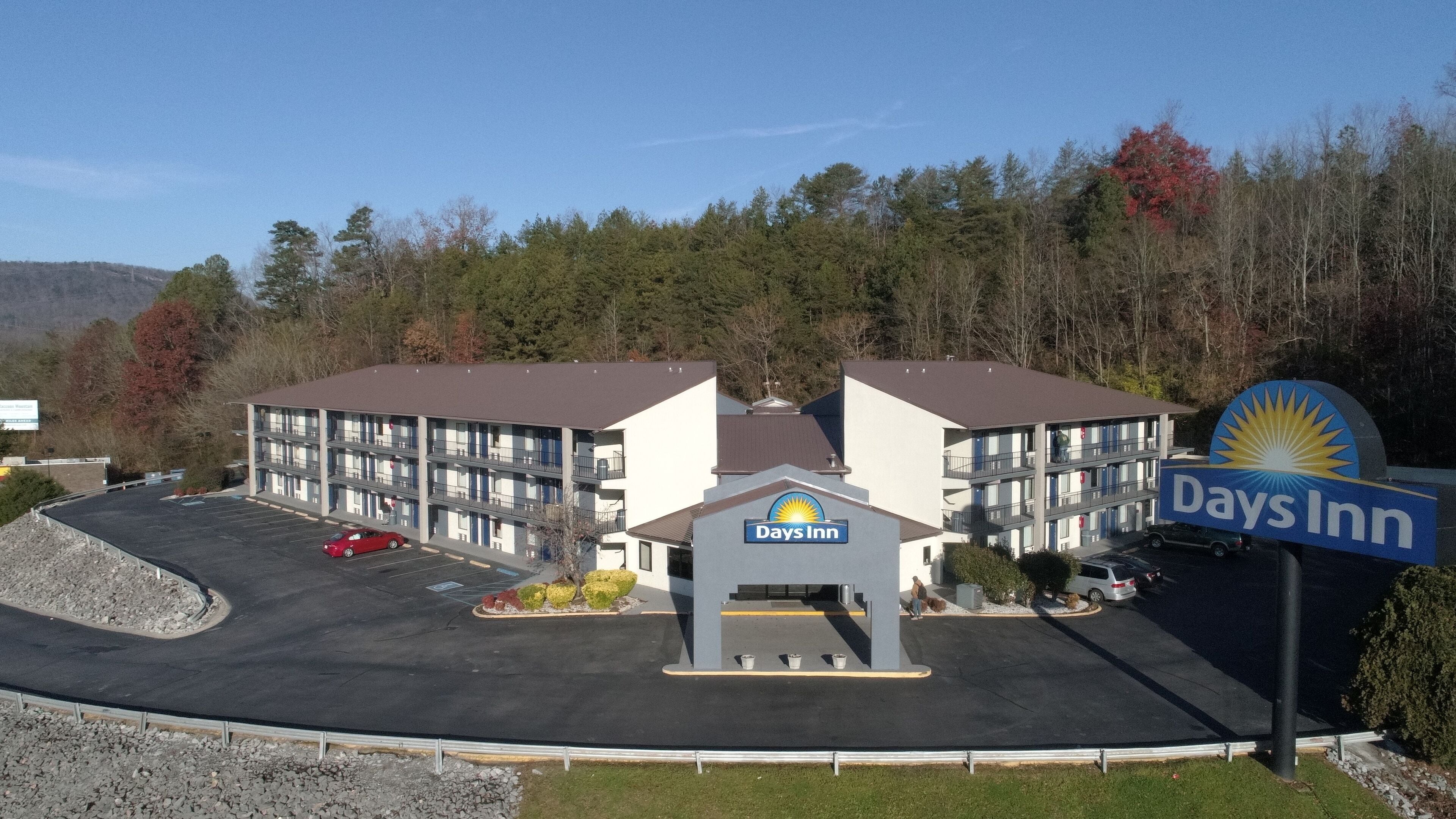 A Days Inn hotel with a parking lot, a building entrance, and a signboard.