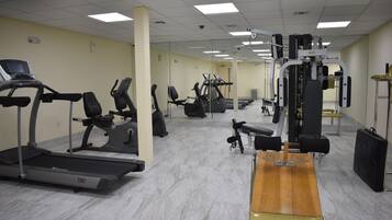 Una palestra con tapis roulant, ellittiche e attrezzature per sollevamento pesi.