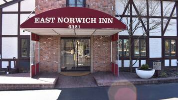 The East Norwich Inn entrance with a red awning and brick facade.