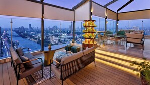 A high-rise apartment with a panoramic city view, a central plant arrangement, and modern furniture. - Sheraton Cairo Hotel & Casino (Giza)