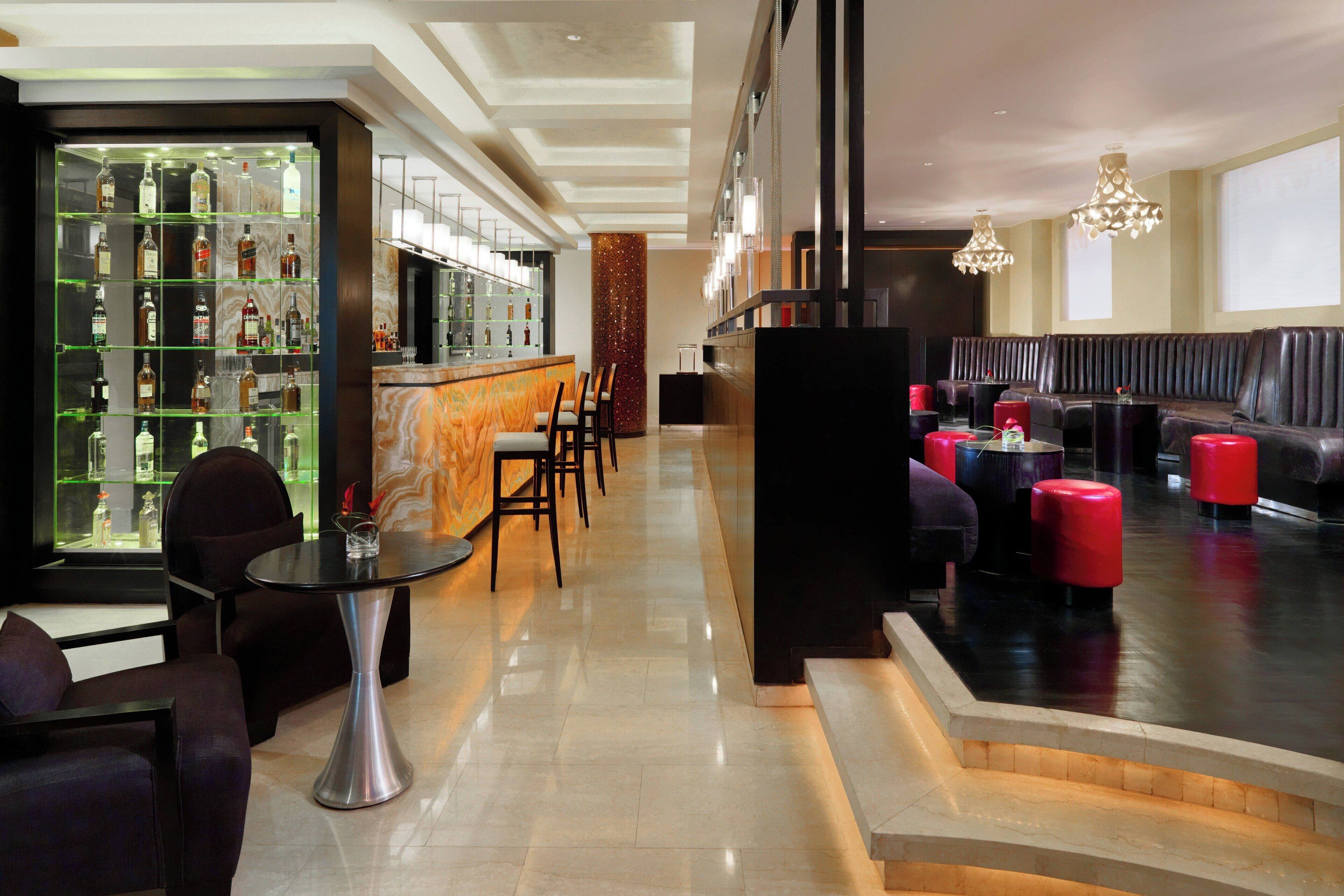 Eine moderne Lobby mit Barbereich, Sitzgelegenheiten und einer Treppe.