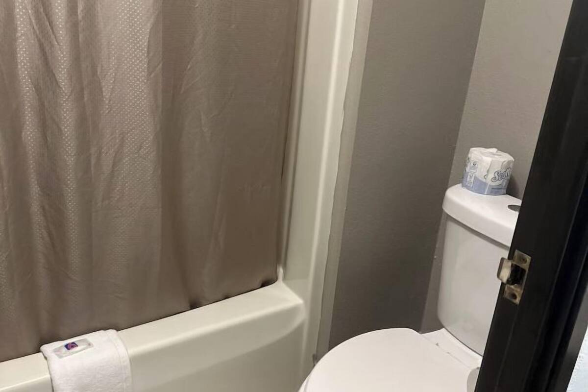 Tina con regadera, amenidades de baño ecológicas, toallas 
