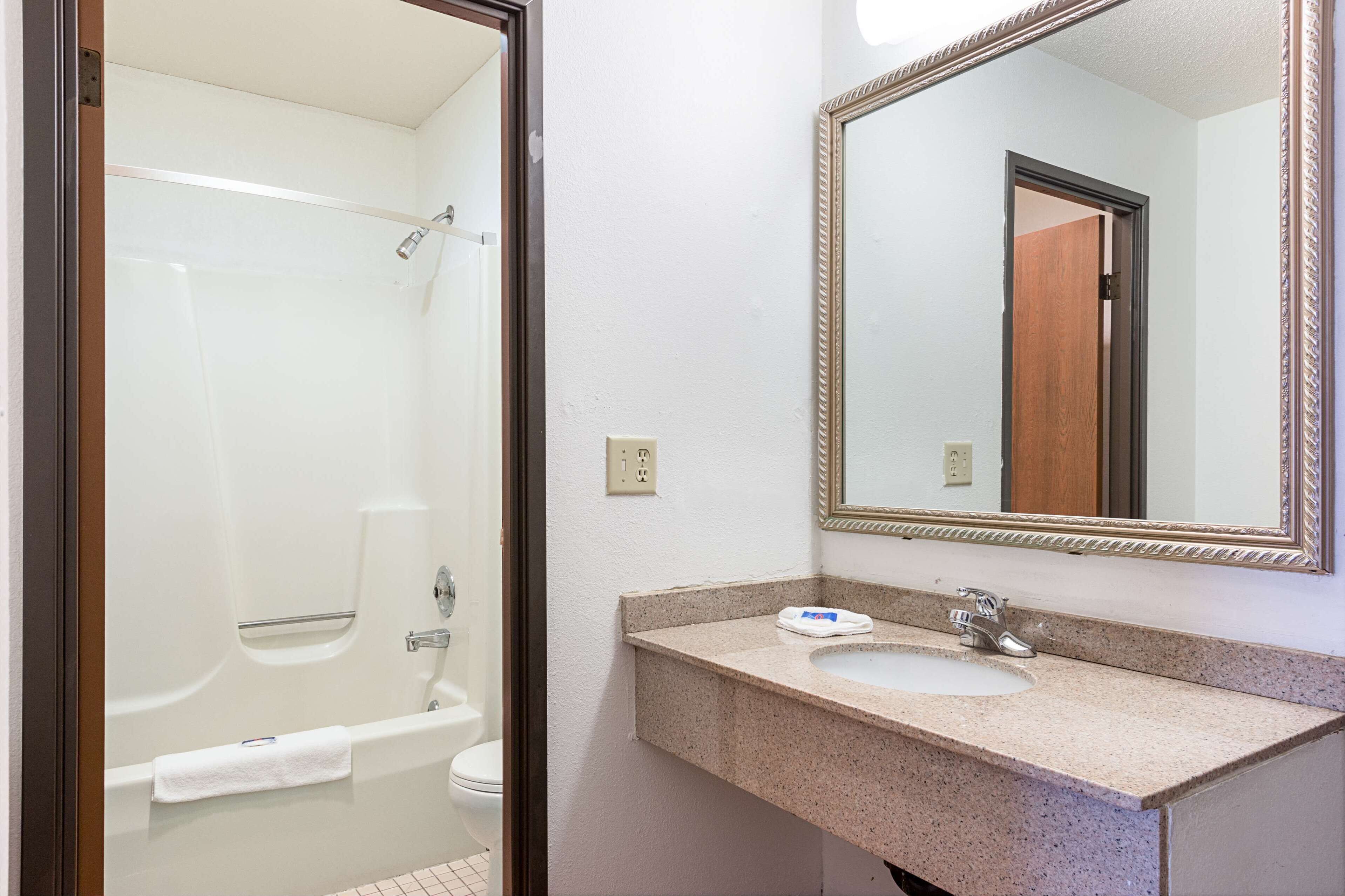 A bathroom with a bathtub, a sink, and a mirror.