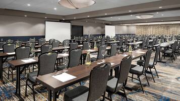 A conference room with multiple tables and chairs, equipped with nameplates and water bottles.