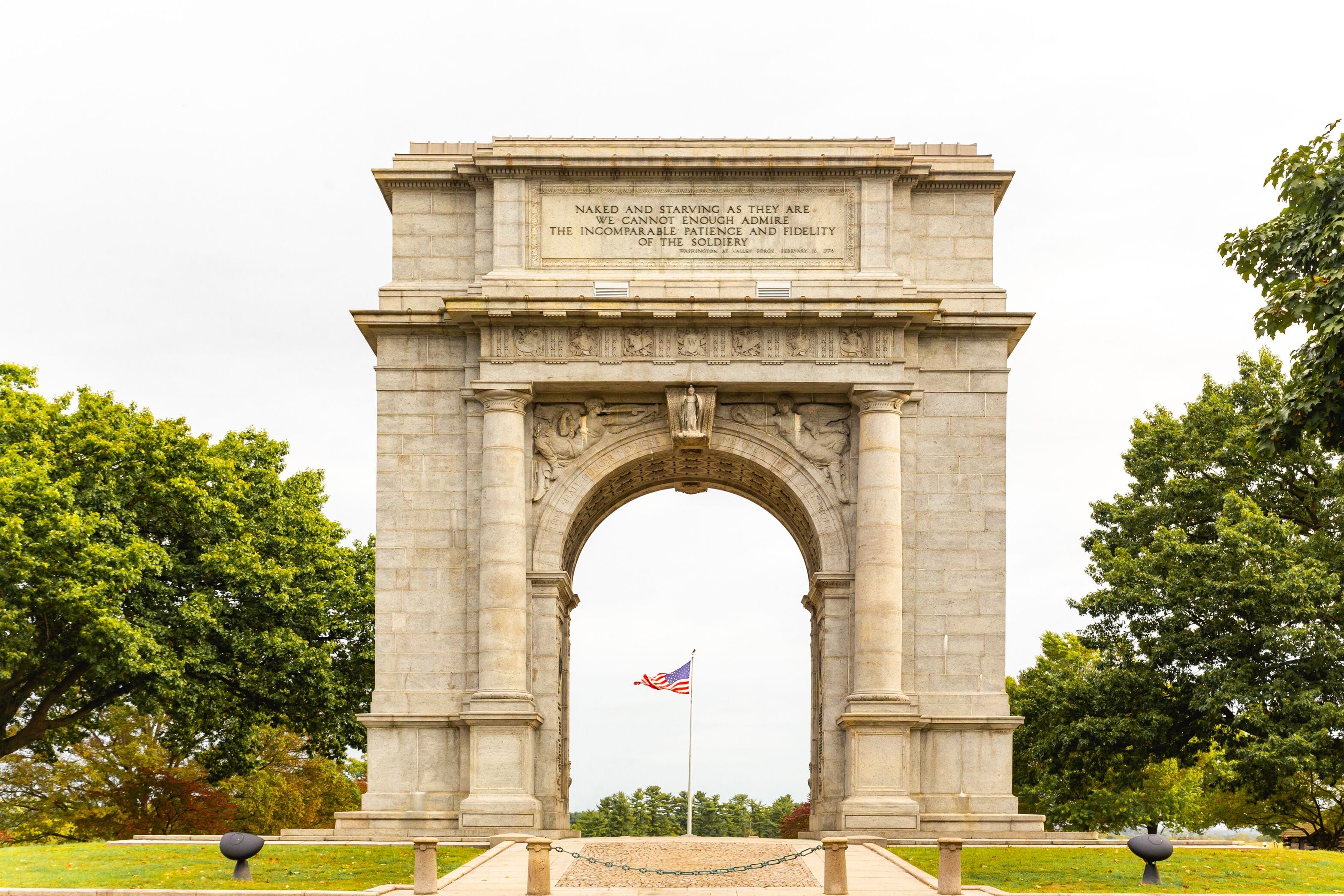 Un monumento de piedra con una bandera estadounidense al frente.