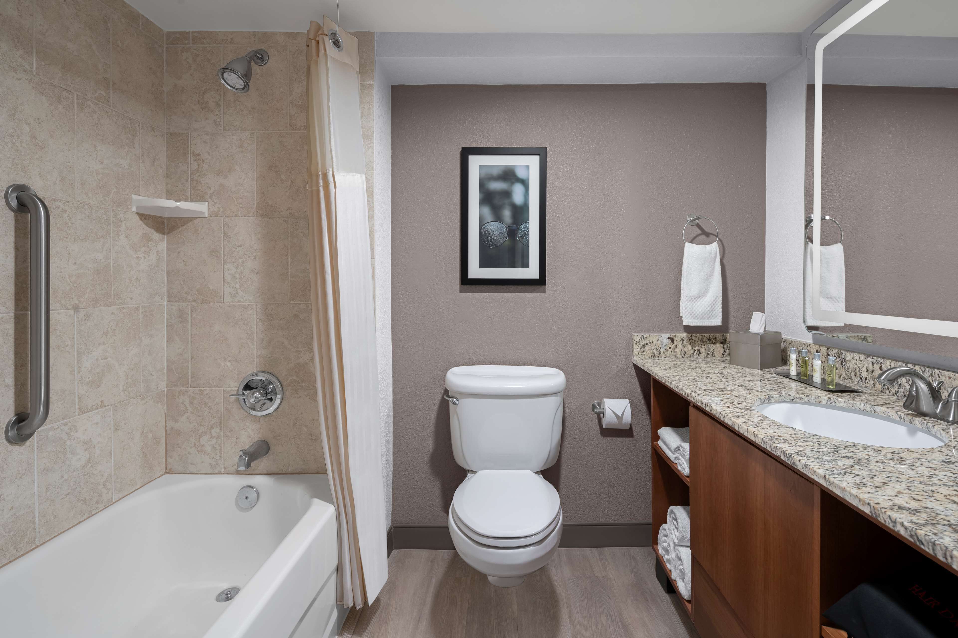 A modern bathroom with a bathtub, toilet, and sink.