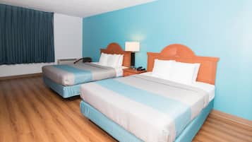 Une chambre d’hôtel avec deux lits, une table de chevet, une lampe et un téléphone.