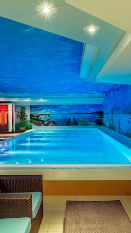 Una piscina techada, sillones reclinables de piscina