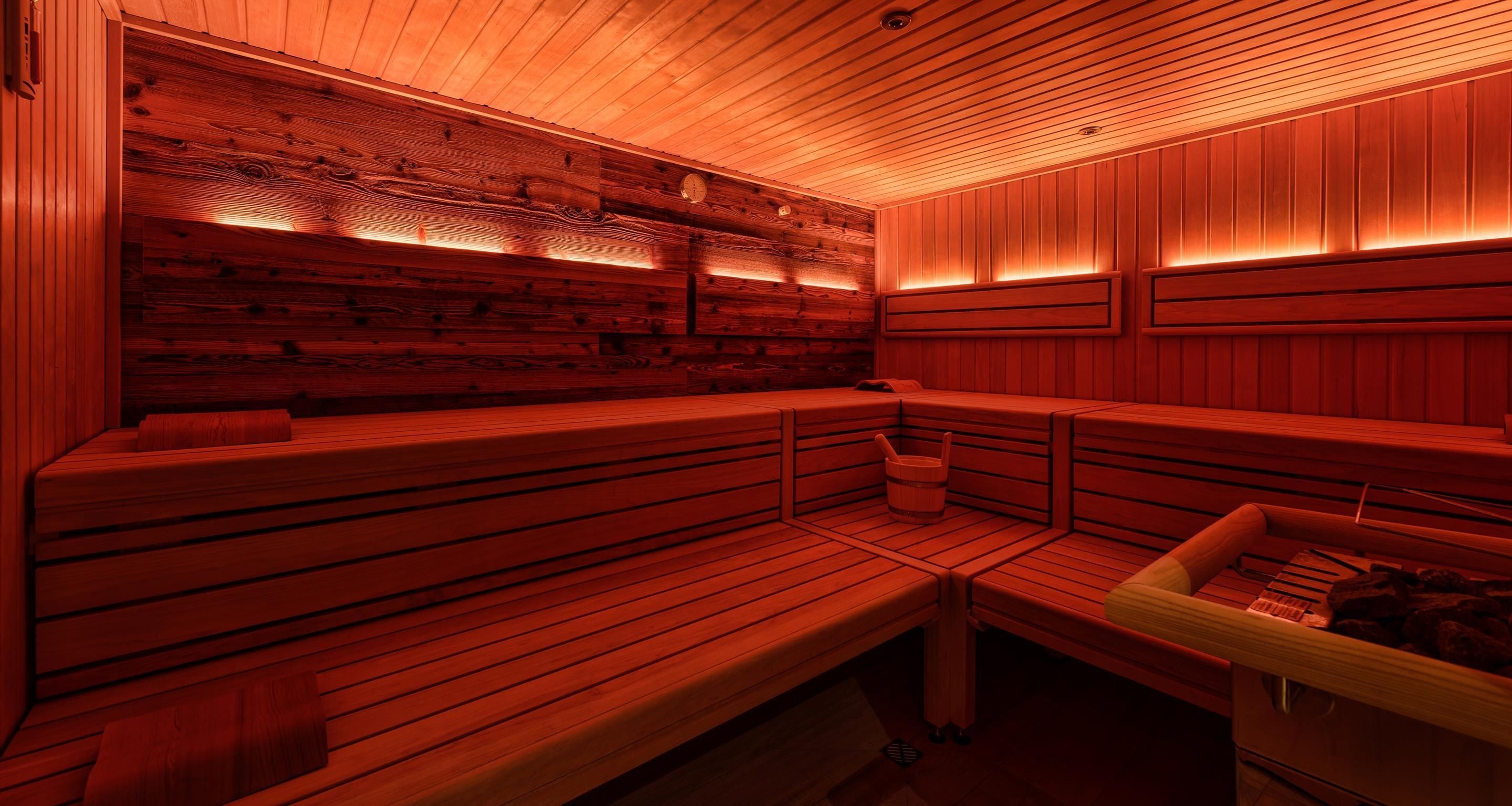 A sauna with wooden benches and a wooden wall.