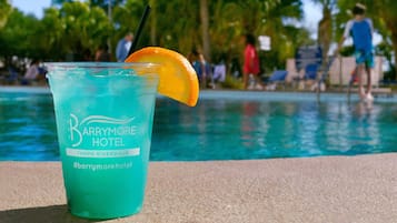 Un vaso de bebida azul con una rodaja de naranja y una pajita, con la etiqueta 'Barrymore Hotel Tampa Riverwalk'.