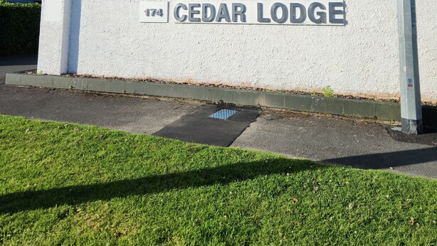 Un bâtiment sur lequel on peut lire l’inscription « CEDAR LODGE » et où le chiffre « 174 » est peint sur le mur.