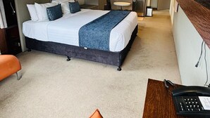 Una habitación de hotel moderna con una cama grande, un escritorio y una kitchenette.