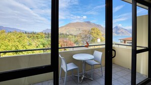 Un balcón con vistas a montañas y árboles.