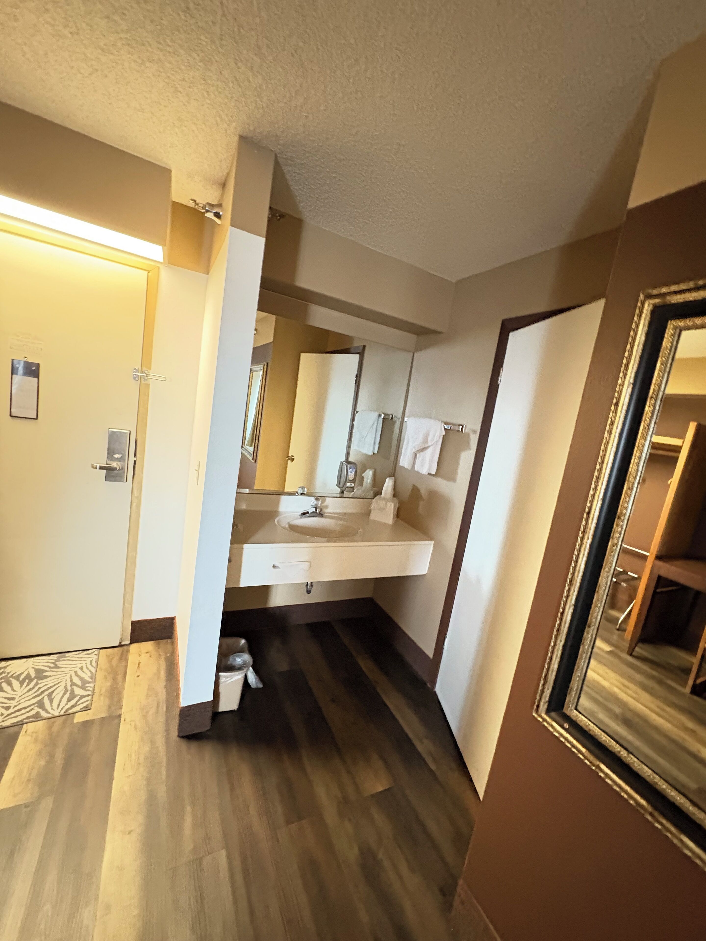 Une salle de bain d’hôtel avec un lavabo, un miroir et un porte-serviettes.