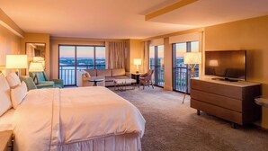 A hotel room with a large bed, a TV, a desk, and a balcony with a view. - Westin Tampa Downtown Waterside (Tampa)