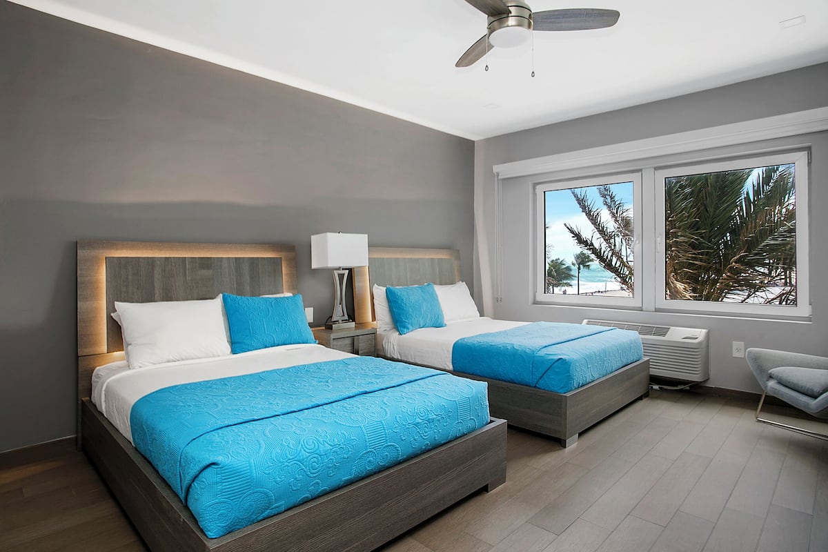 Habitación estándar, 2 camas matrimoniales, vista parcial al océano | Ropa de cama de alta calidad y caja de seguridad en la habitación