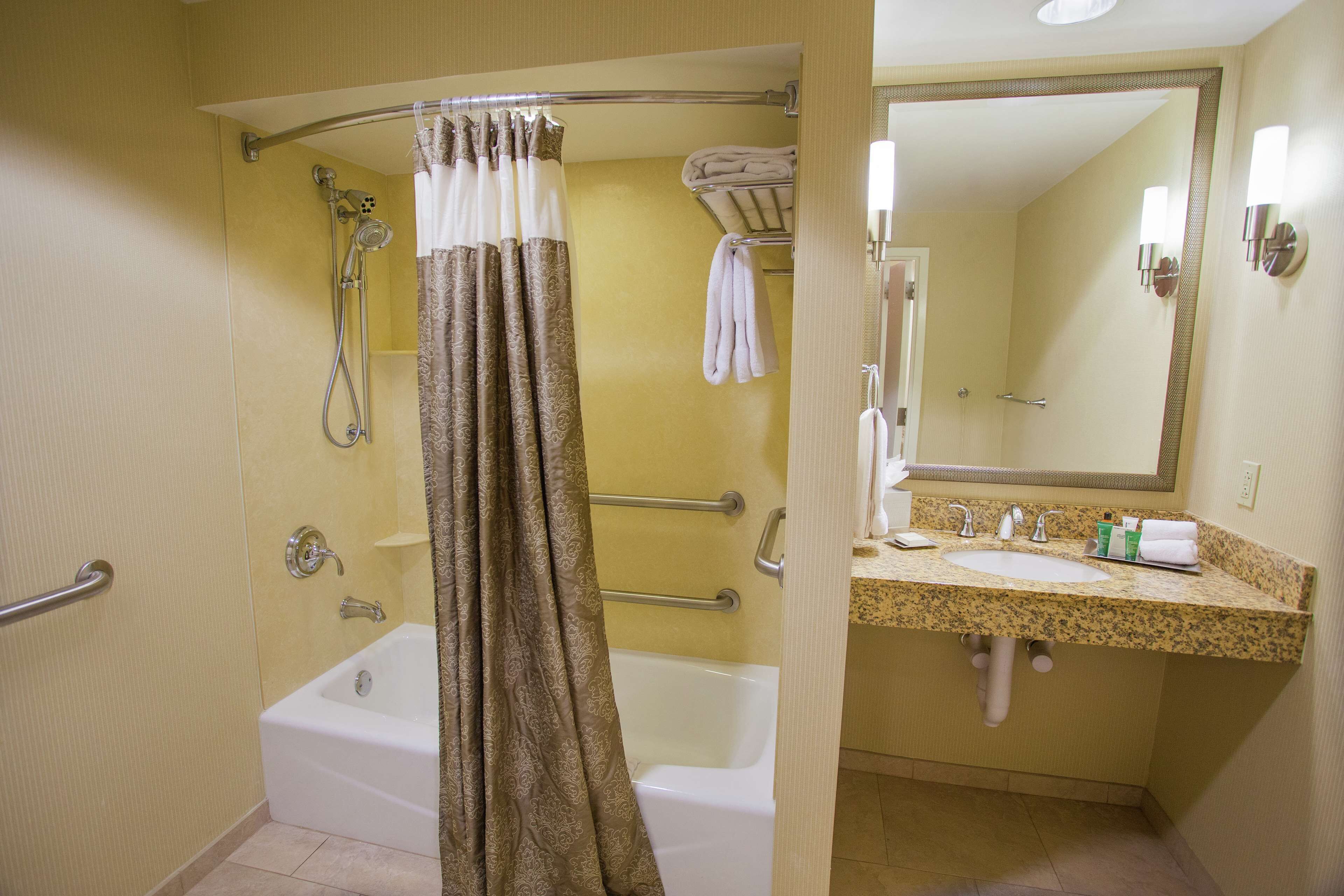 A bathroom with a shower, a bathtub, a sink, and a mirror.