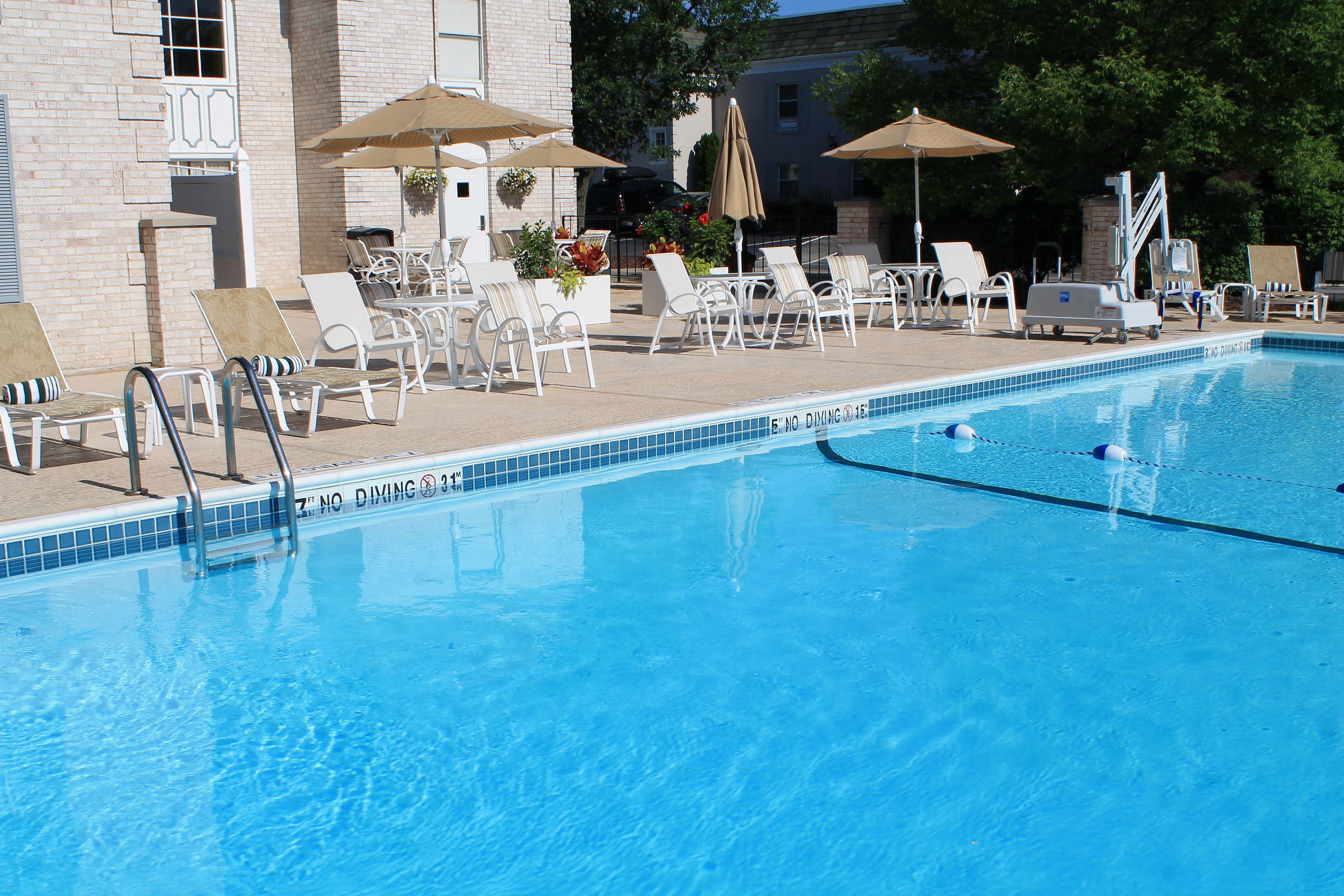 A clear blue pool with lounge chairs and umbrellas.