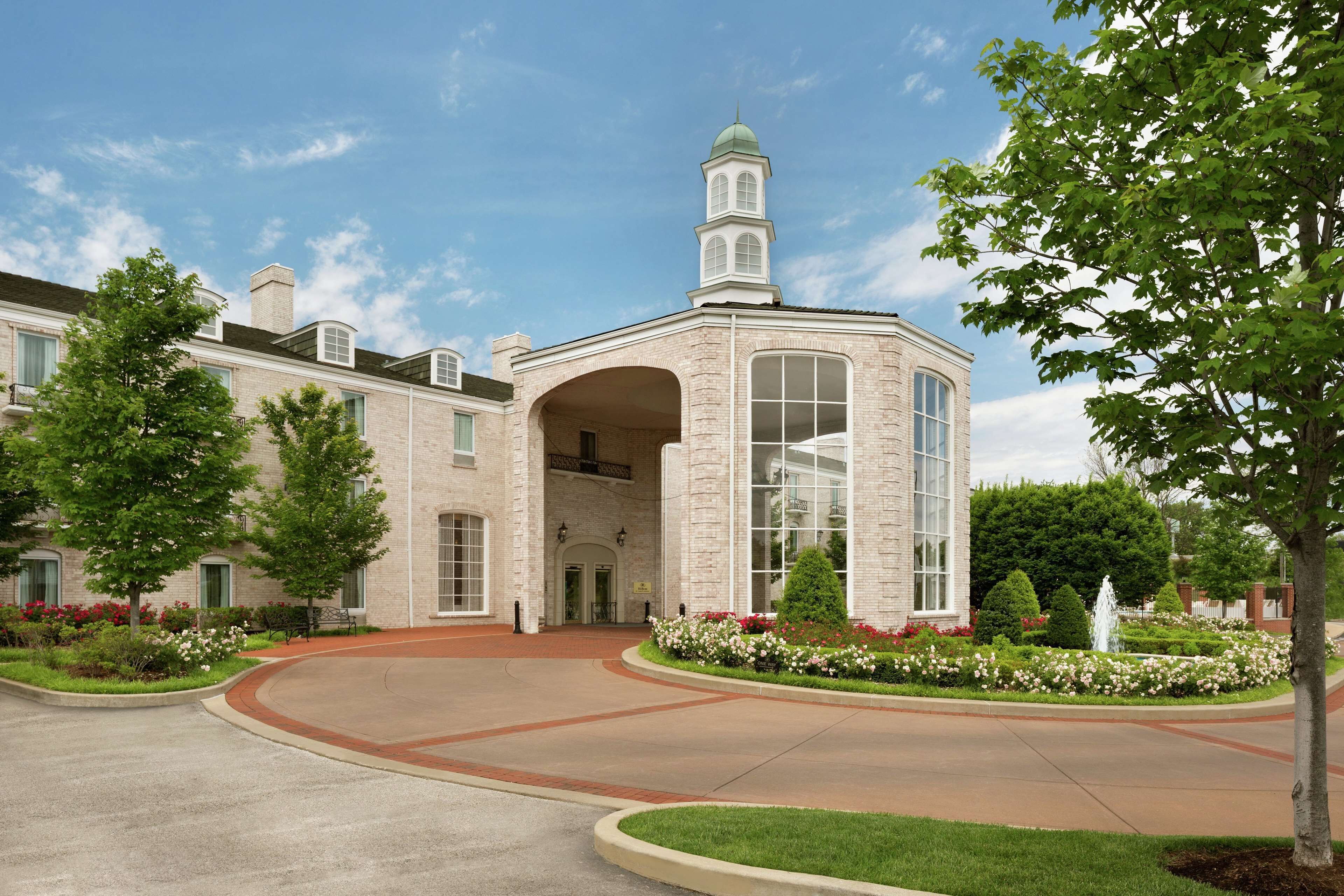 A large, multi-story building with a prominent tower and arched entrance.