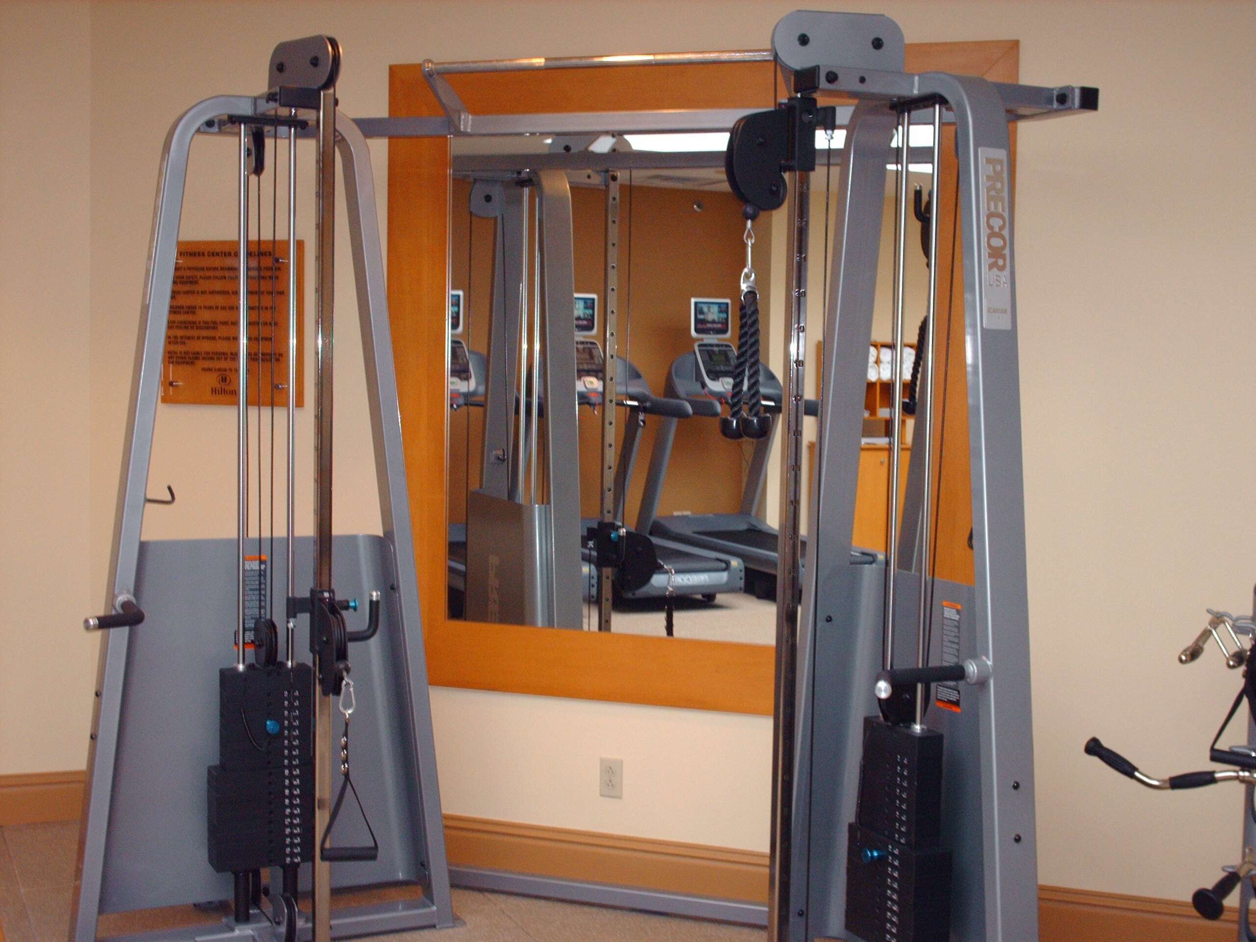 A gym with exercise equipment, a treadmill, and a mirror.