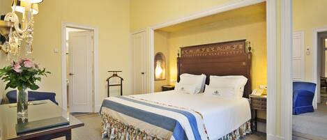 A hotel room with a large bed, a bedside table, a lamp, and a mirror.
