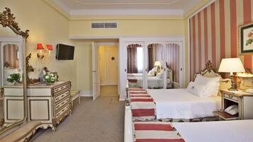 A hotel room with two beds, a large mirror, a dresser, a television, and a telephone.