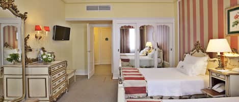 Ein Hotelzimmer mit zwei Betten, einem großen Spiegel, einem Schminktisch, einem Fernseher und einem Telefon.