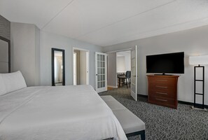 A hotel room with a large bed, a dresser, a television, and a desk with a chair. - Homewood Suites by Hilton Chicago-Lincolnshire (Lincolnshire)