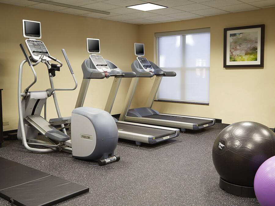 A gym with treadmills, a stationary bike, and exercise balls.
