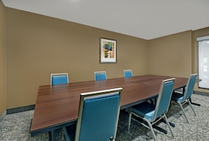 Una sala de conferencias con una larga mesa y seis sillas.