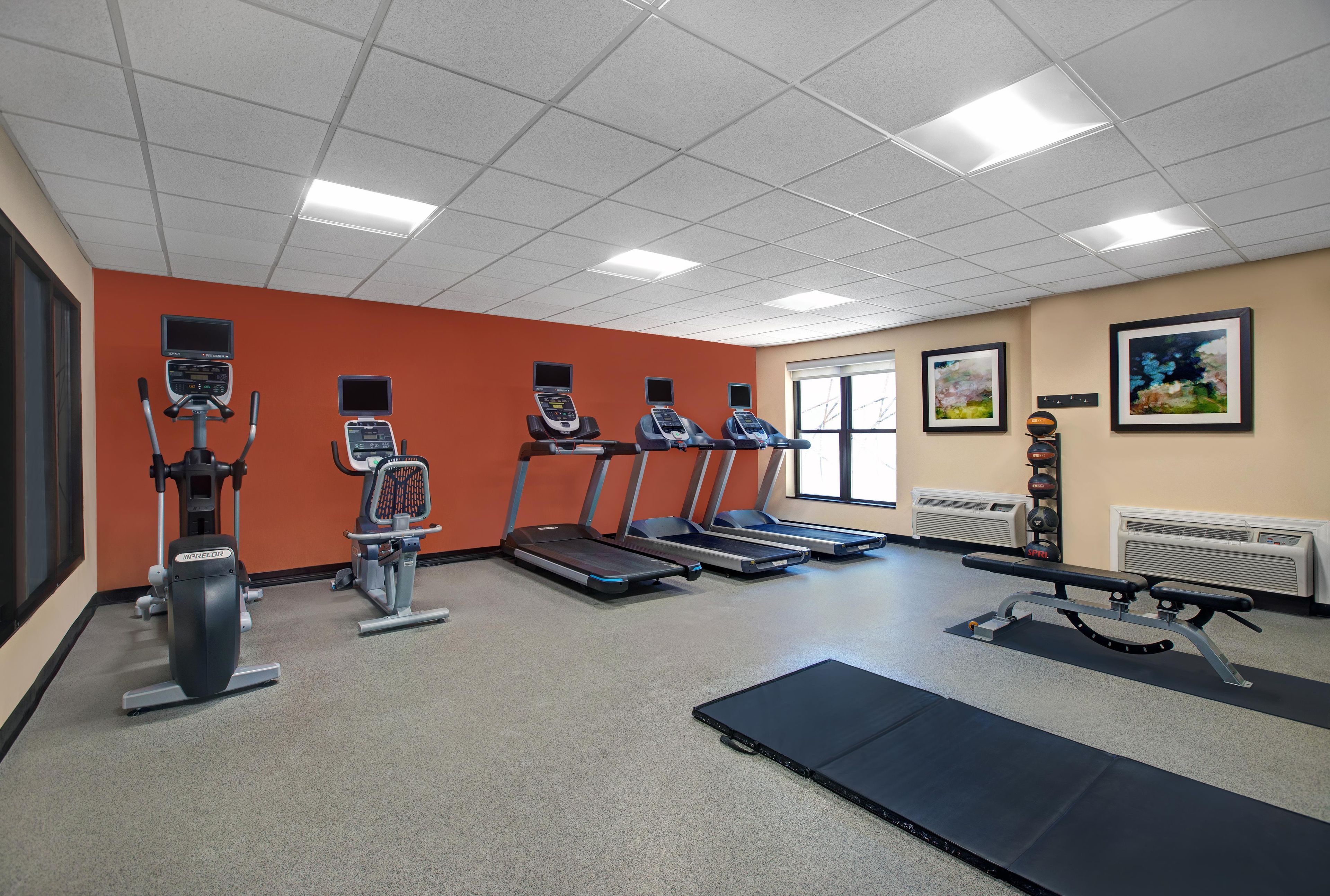 A gym with treadmills, elliptical machines, and a rowing machine.