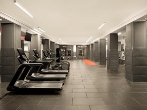 A gym with treadmills, weight machines, and a red carpet leading to a door. - The Waldorf Hilton, London (London)