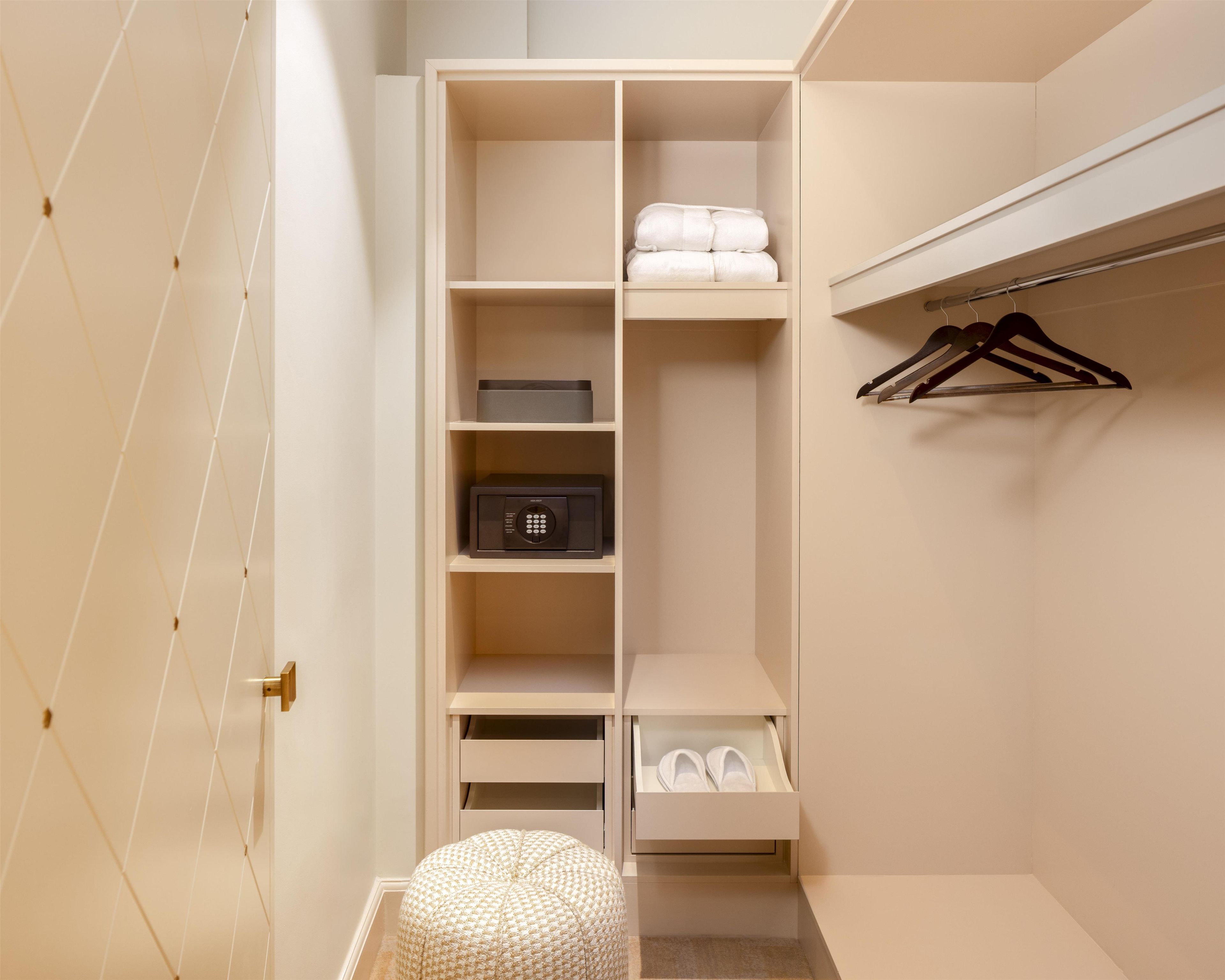 Un vestidor con estantes abiertos, una barra para colgar ropa y un espacio para guardar zapatos.