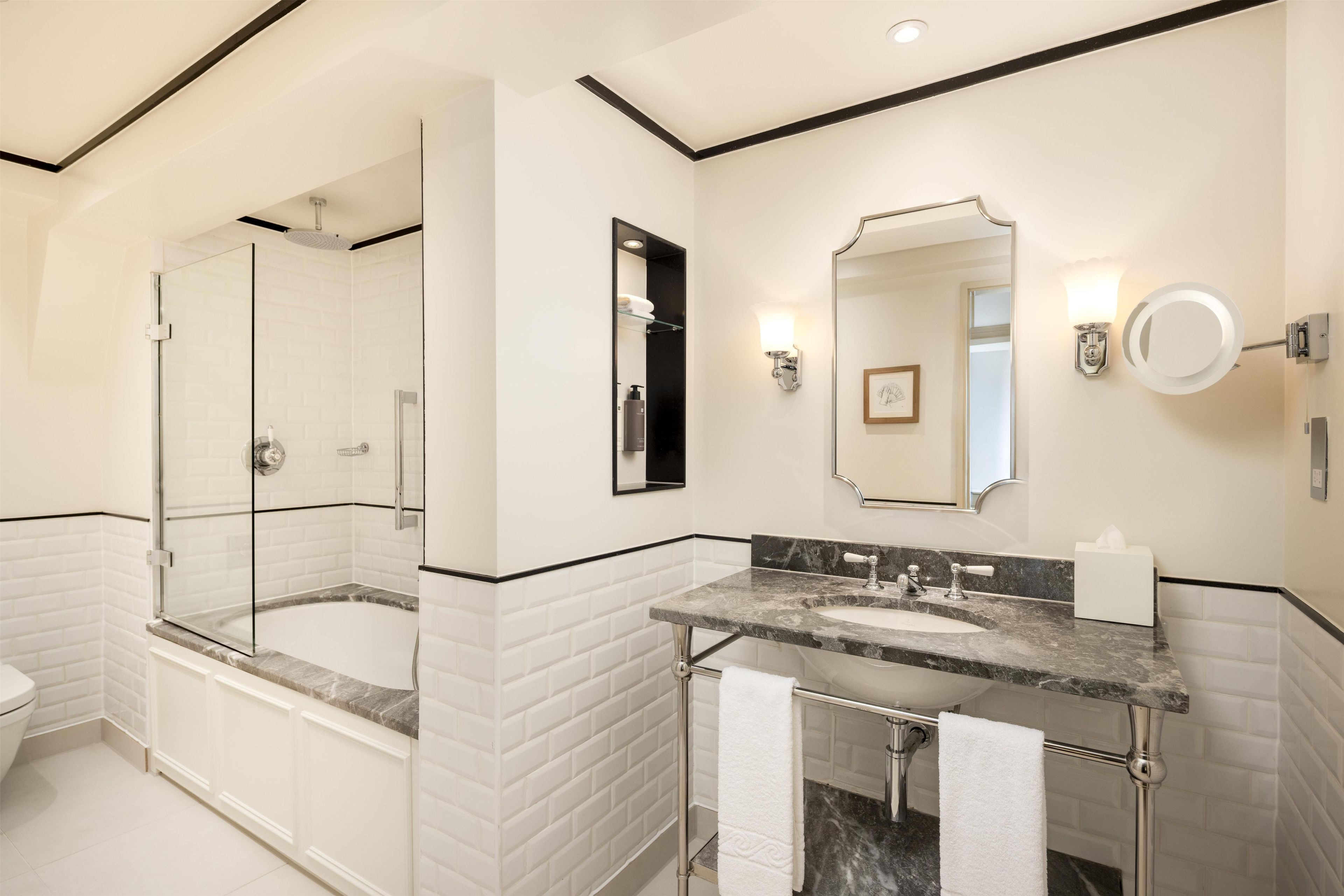 A modern bathroom with a glass-enclosed shower, a double sink vanity, and a large mirror.